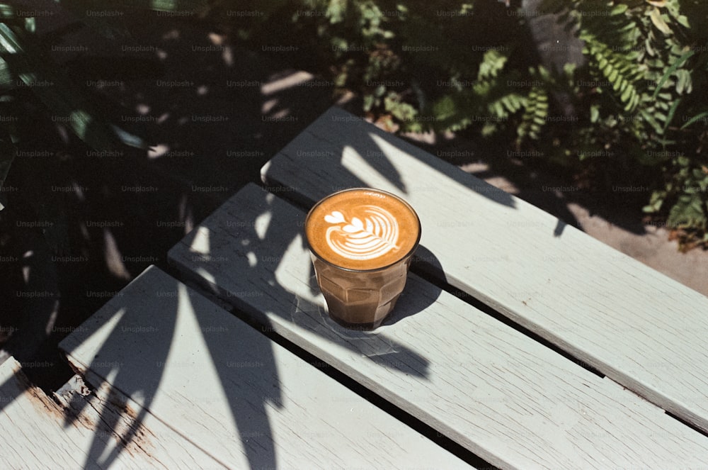 a cup of coffee sitting on top of a wooden table