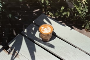 a cup of coffee sitting on top of a wooden table