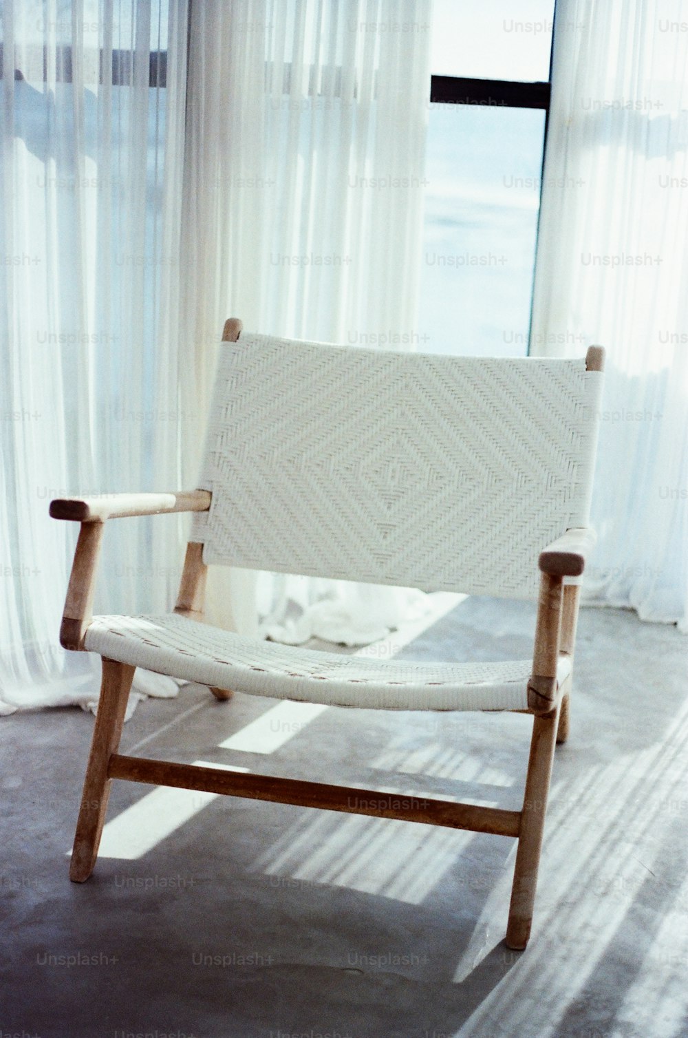 Ein weißer Stuhl sitzt vor einem Fenster