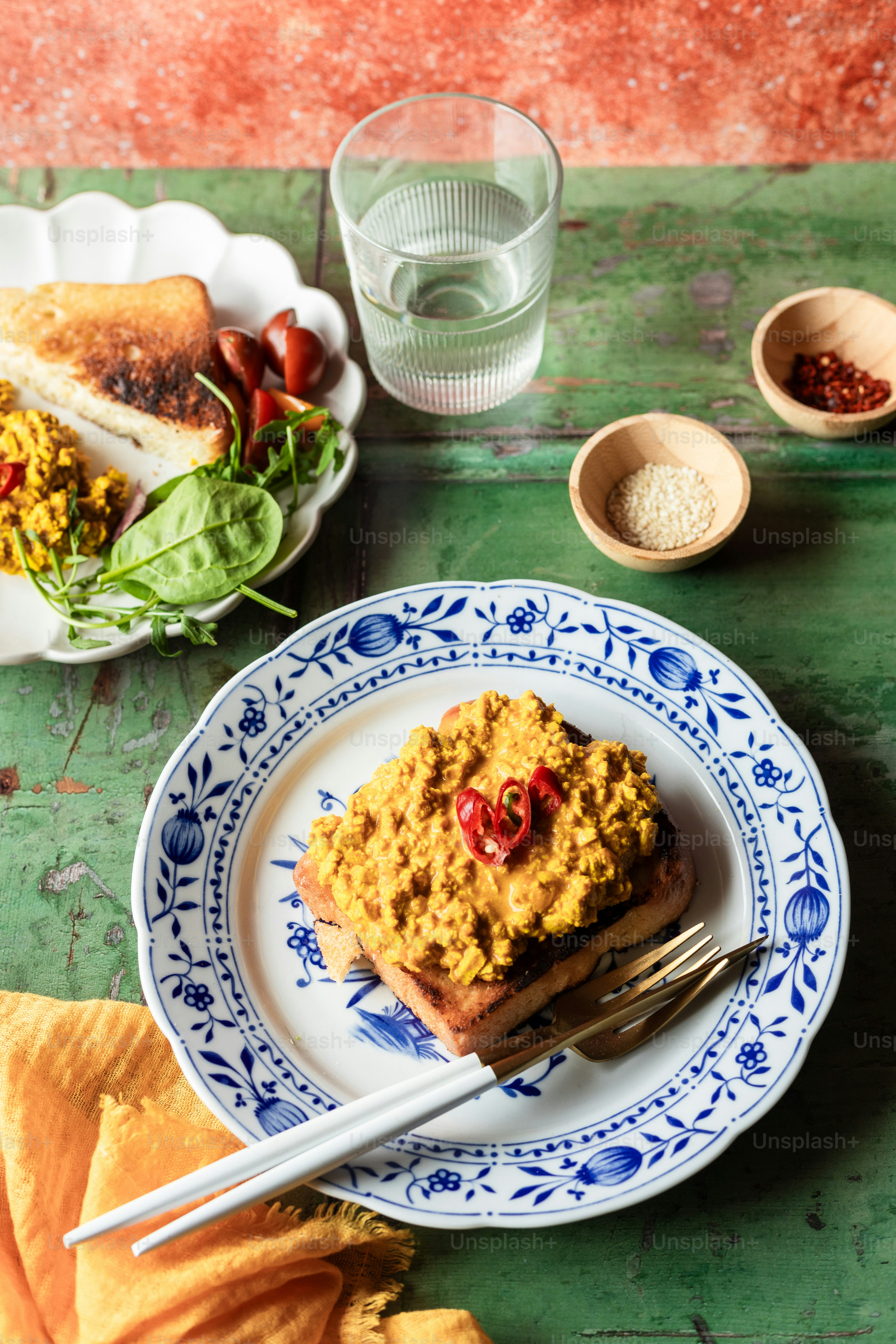 コップ一杯の水の隣に食べ物が載った皿