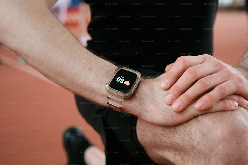a man holding his arm with an apple watch on it