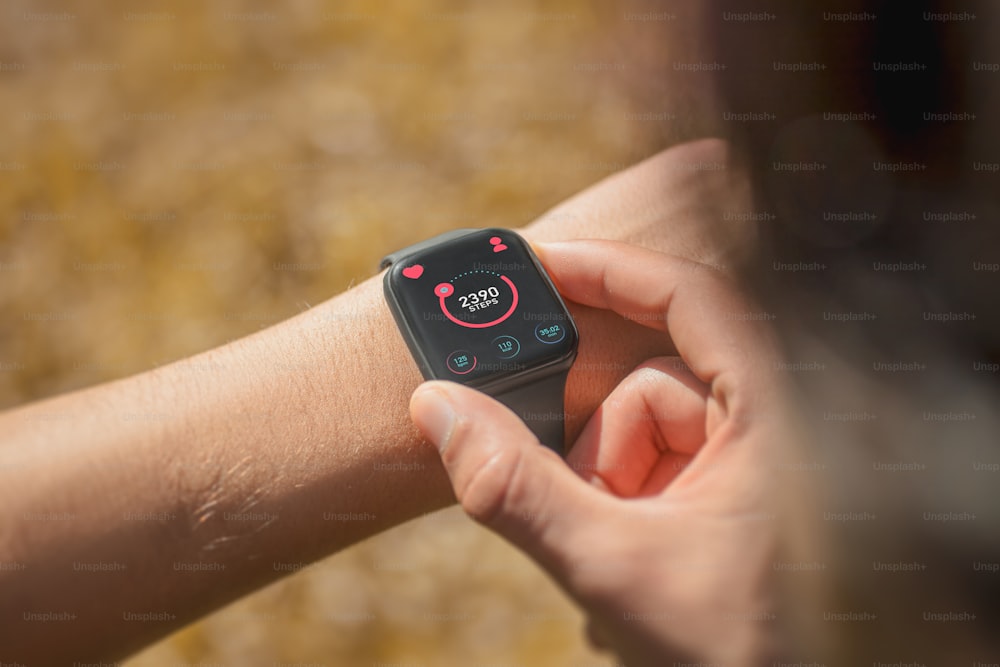 Un primo piano di una persona che tiene in mano uno smartwatch