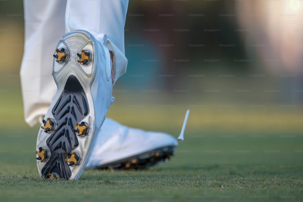a close up of a person's shoes on a field