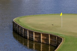 ein Golfplatz mit gelber Flagge auf dem Wasser