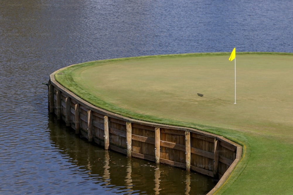 a golf course with a yellow flag on the water