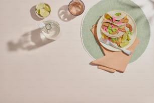 a white plate topped with a salad next to a glass of water