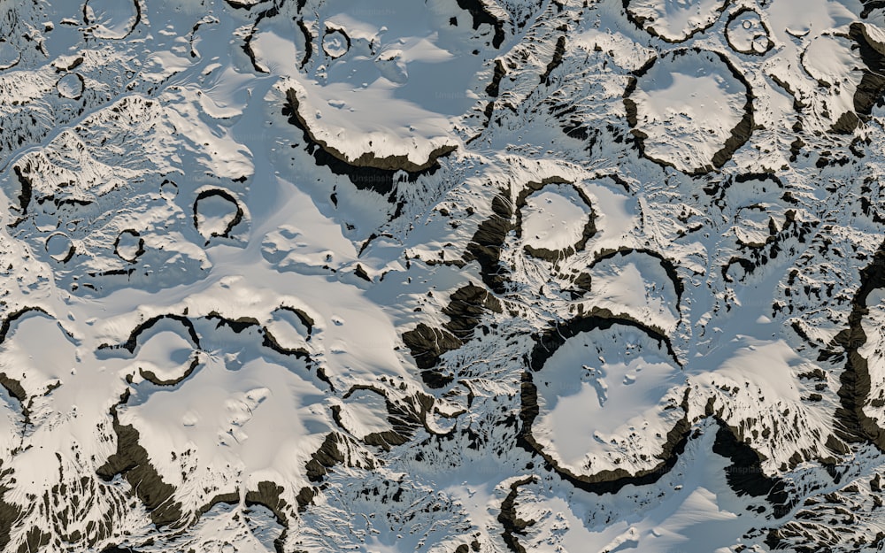 an aerial view of snow covered mountains and valleys