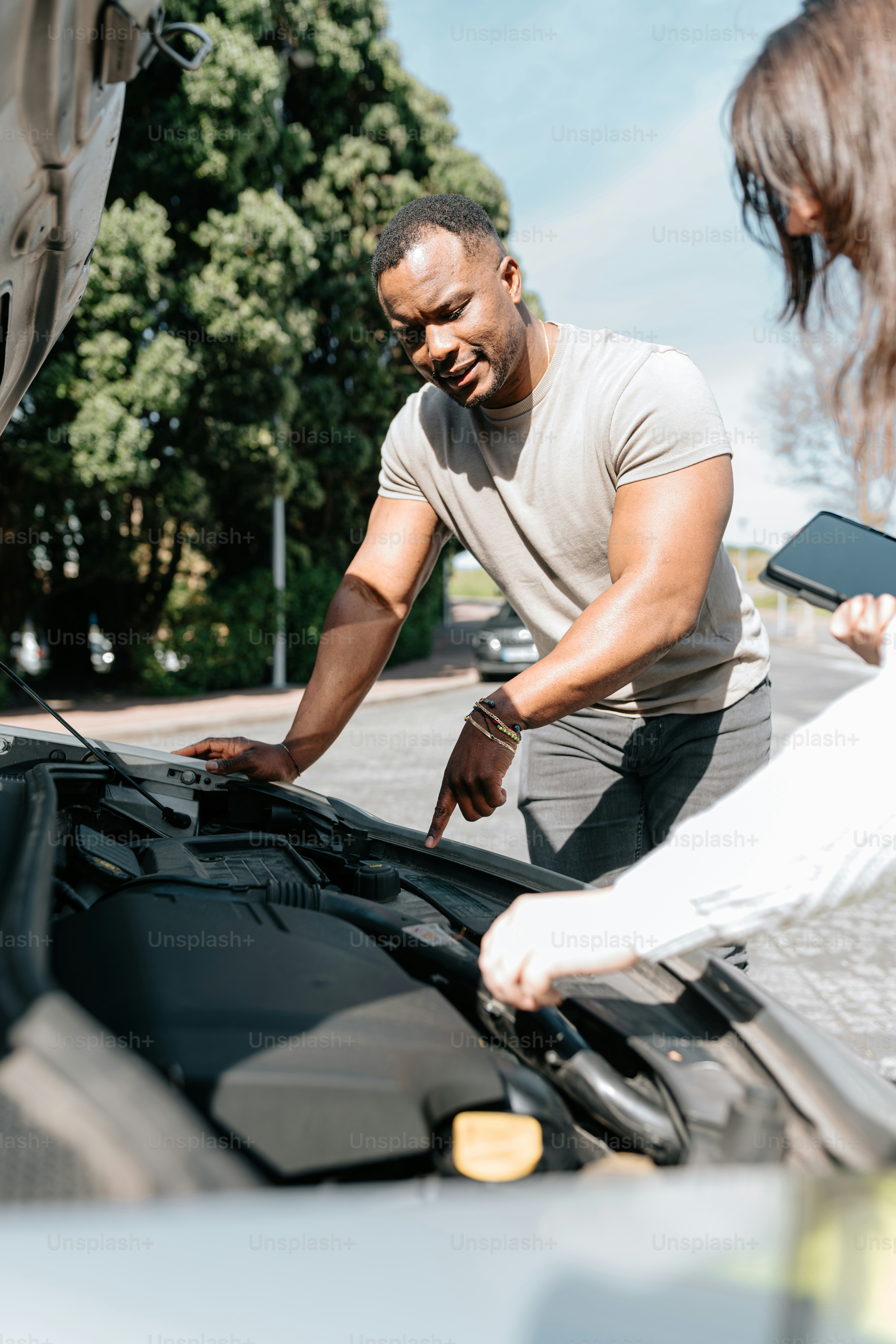 Un par de personas que están trabajando en un coche