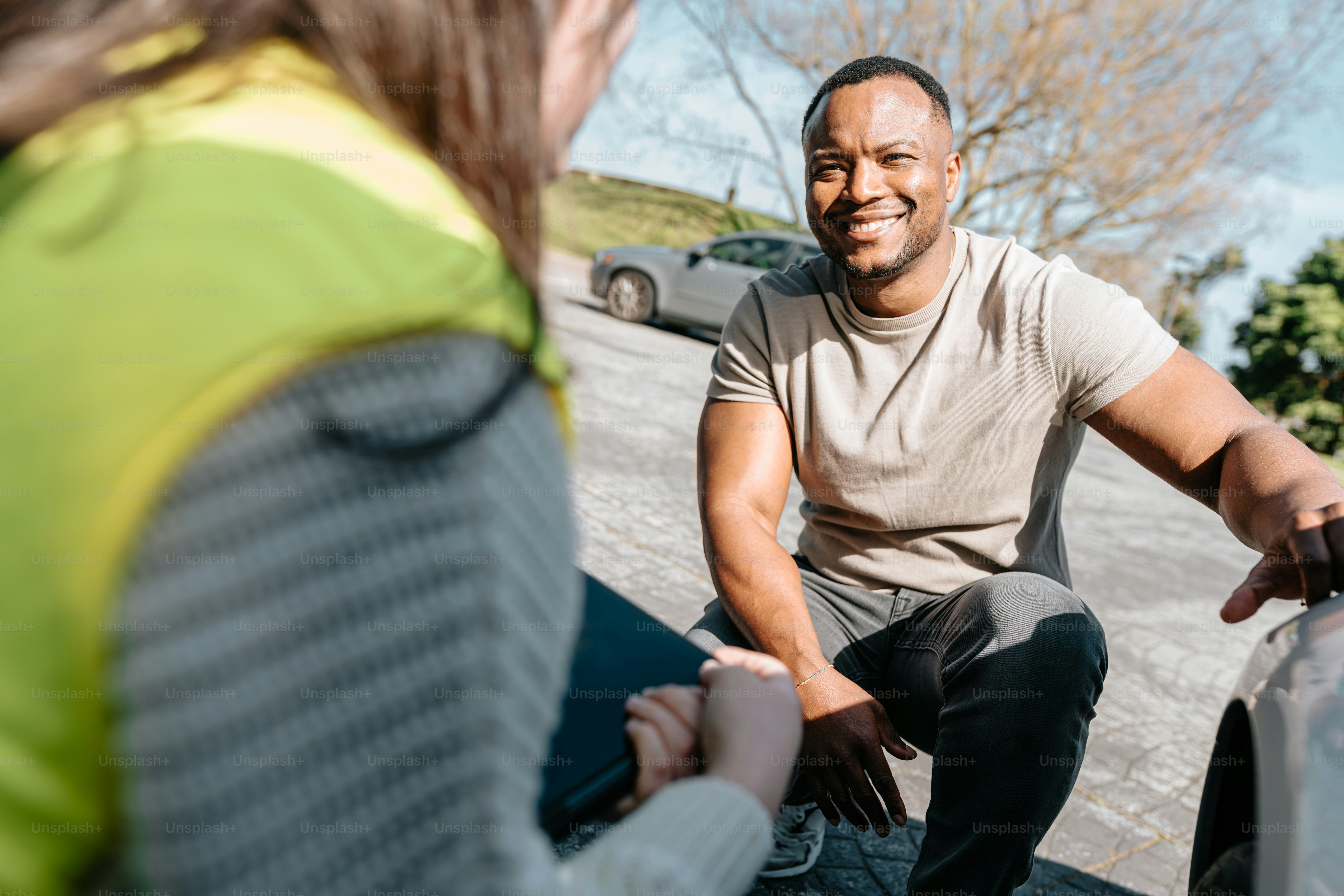 Un hombre sentado junto a una mujer al costado de una carretera
