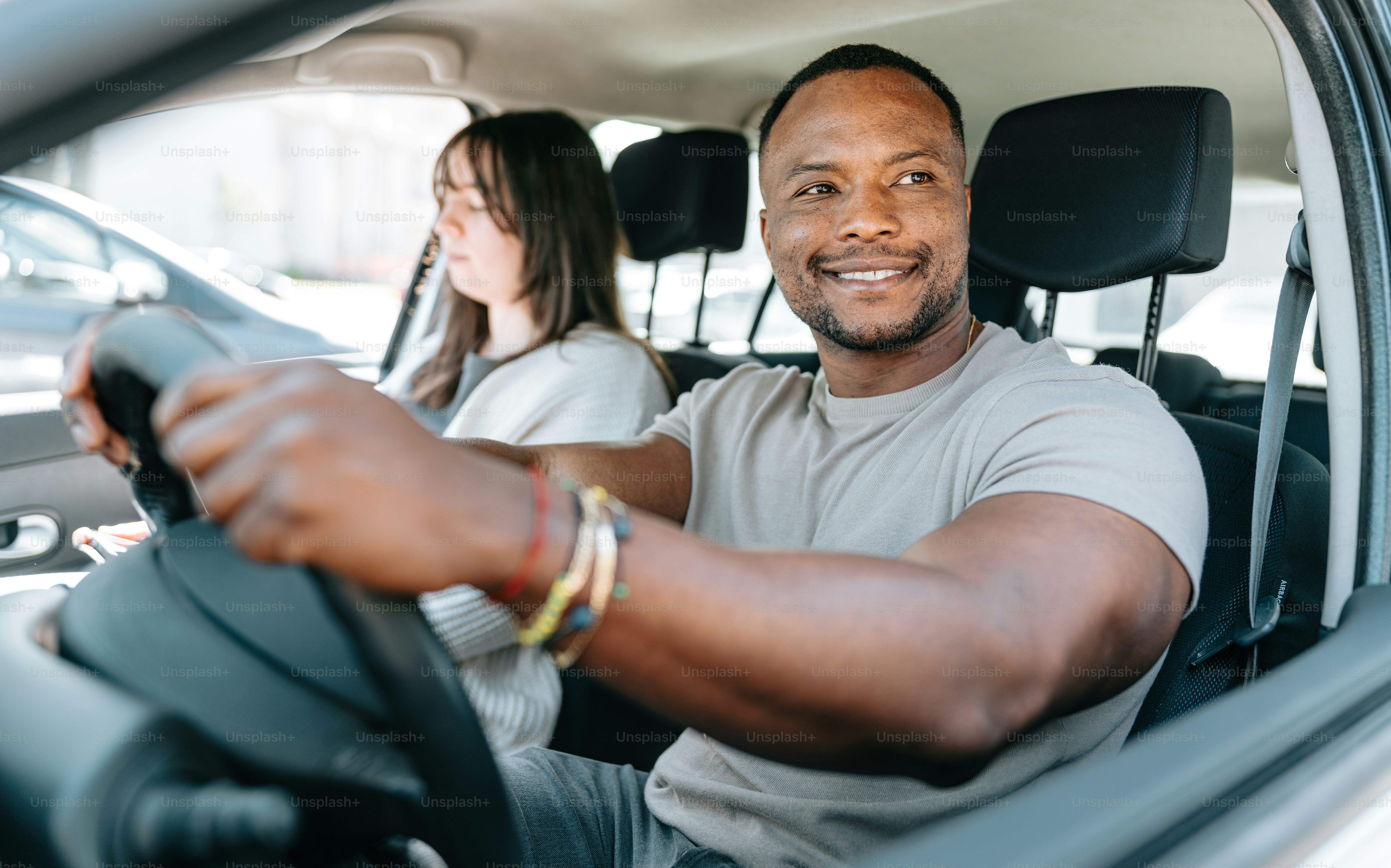 un homme conduisant une voiture avec une femme derrière lui