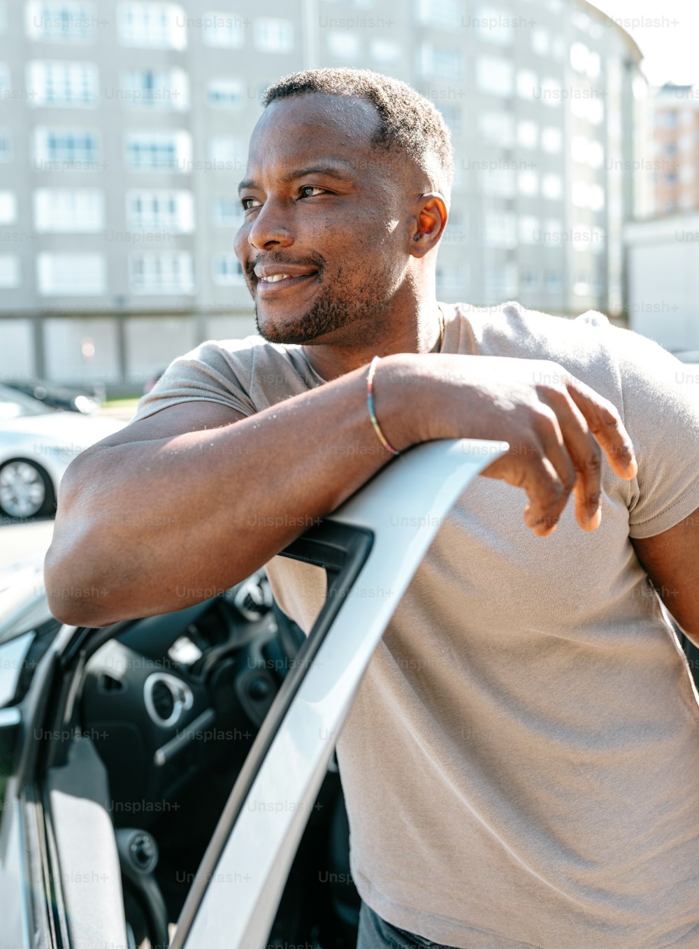 a man leaning on the door of a car