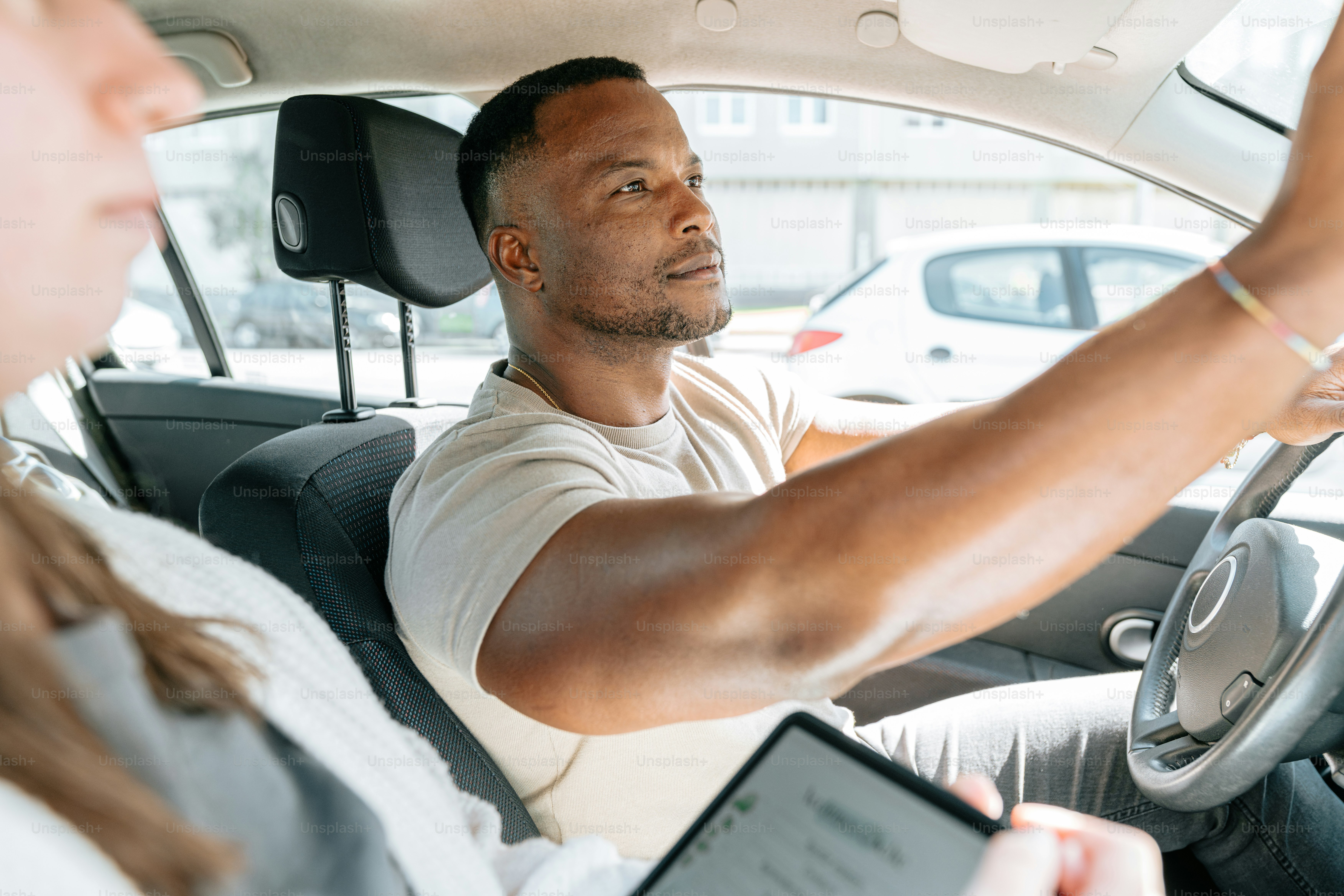Un homme conduisant une voiture en tenant une tablette