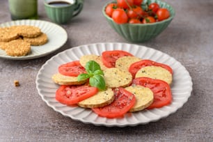 얇게 썬 토마토와 크래커를 얹은 흰 접시