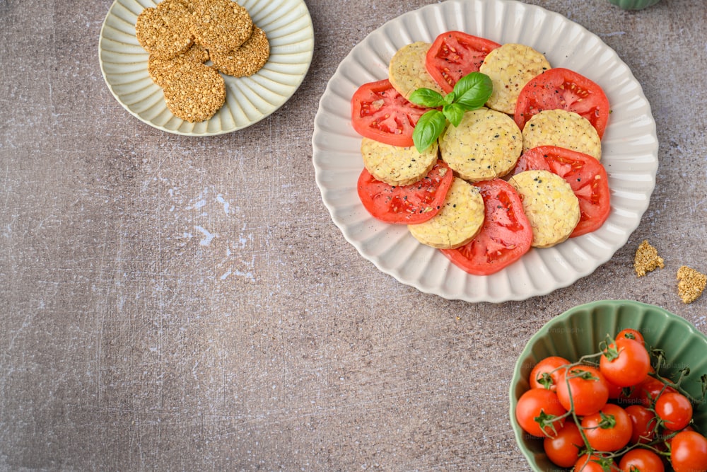 a plate of tomatoes and crackers on a table