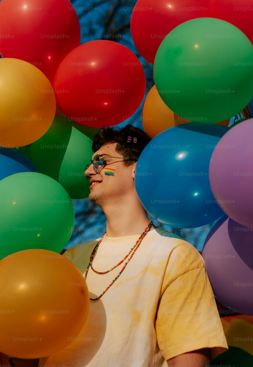 a man standing in front of a bunch of balloons