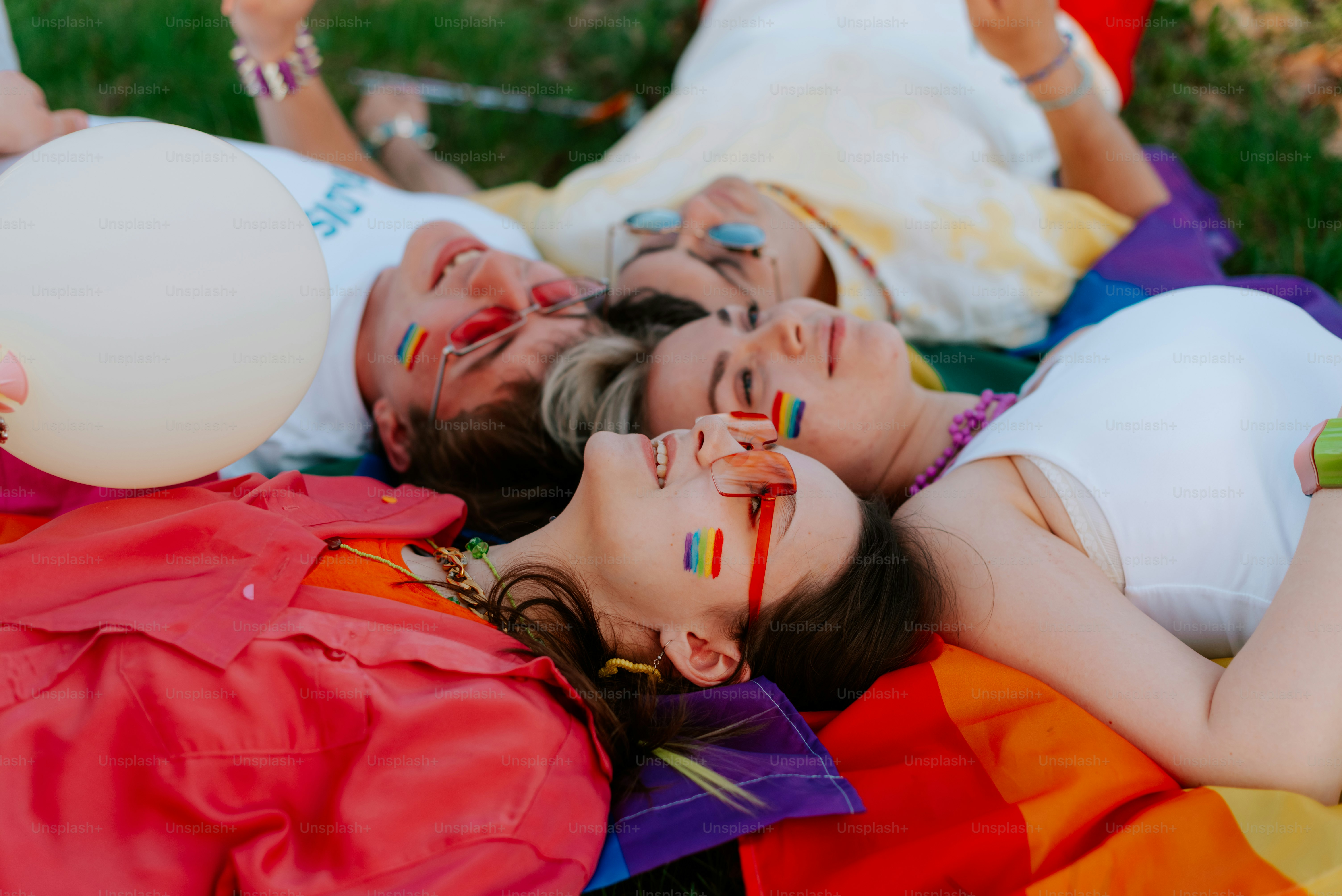 a group of people laying on top of a lush green field