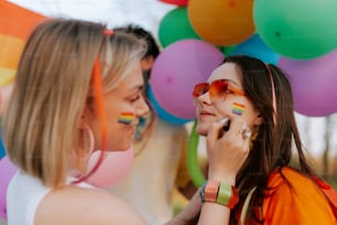 two women with rainbow painted on their faces