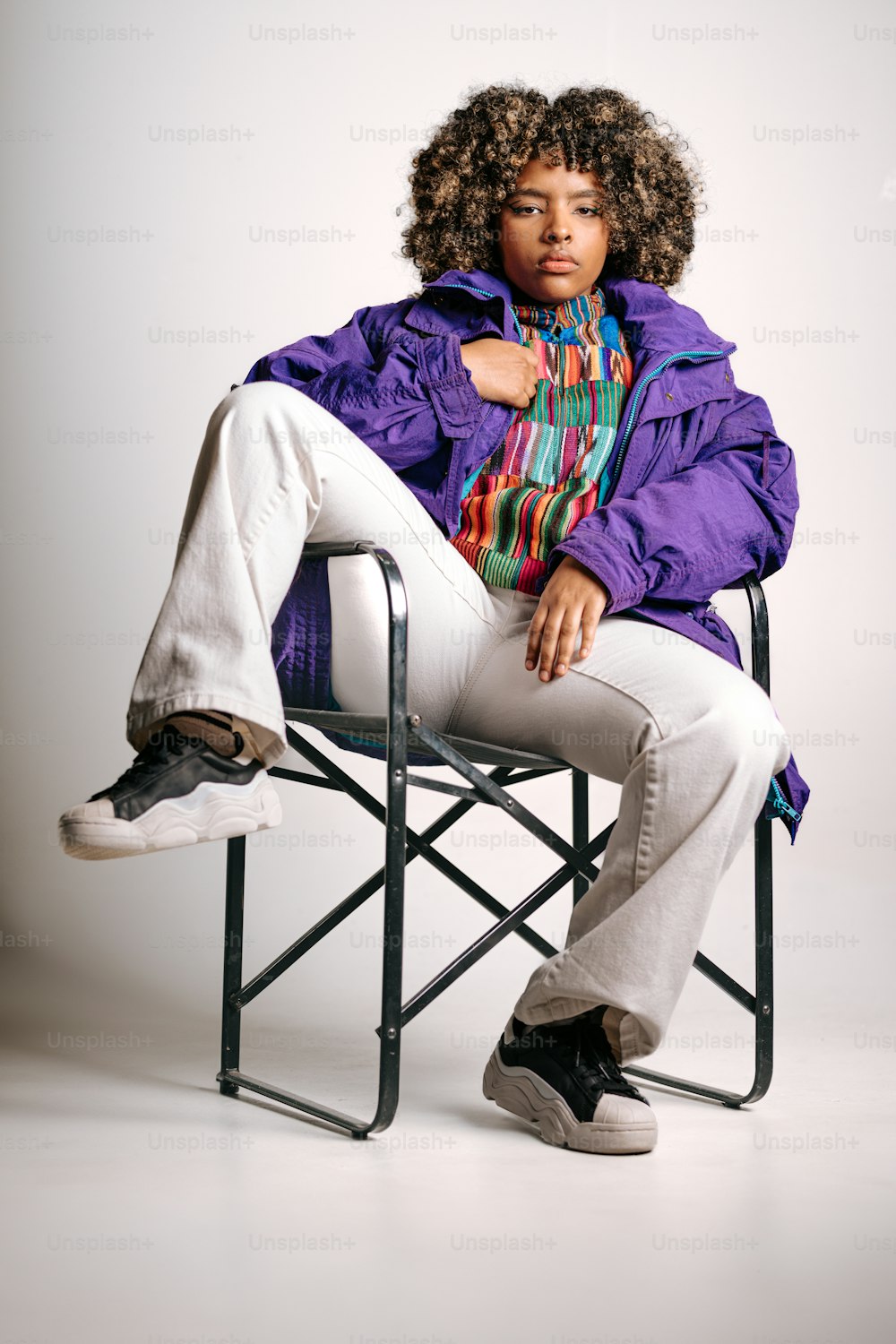 a woman in a purple jacket sitting on a chair