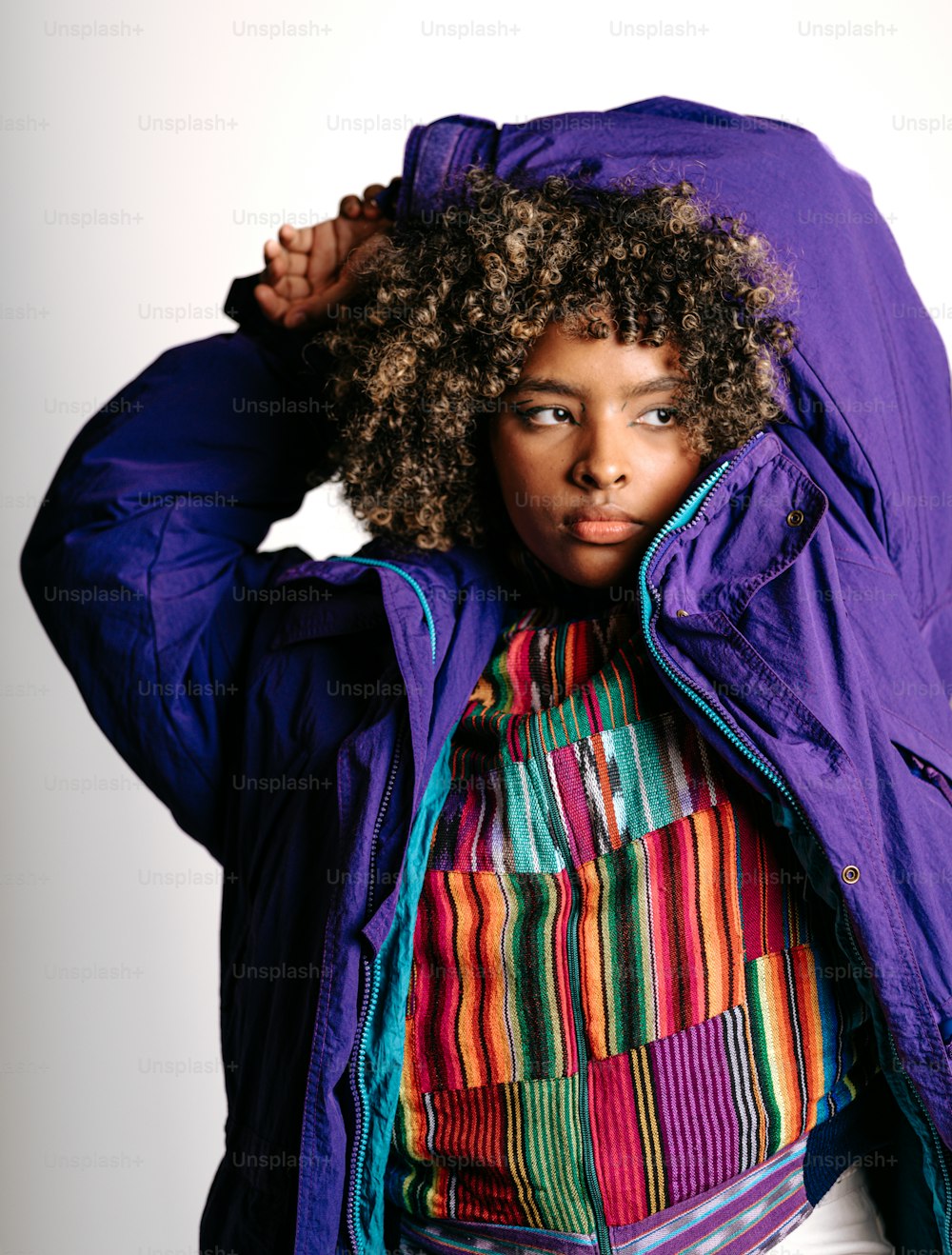 a woman wearing a purple jacket and a colorful shirt
