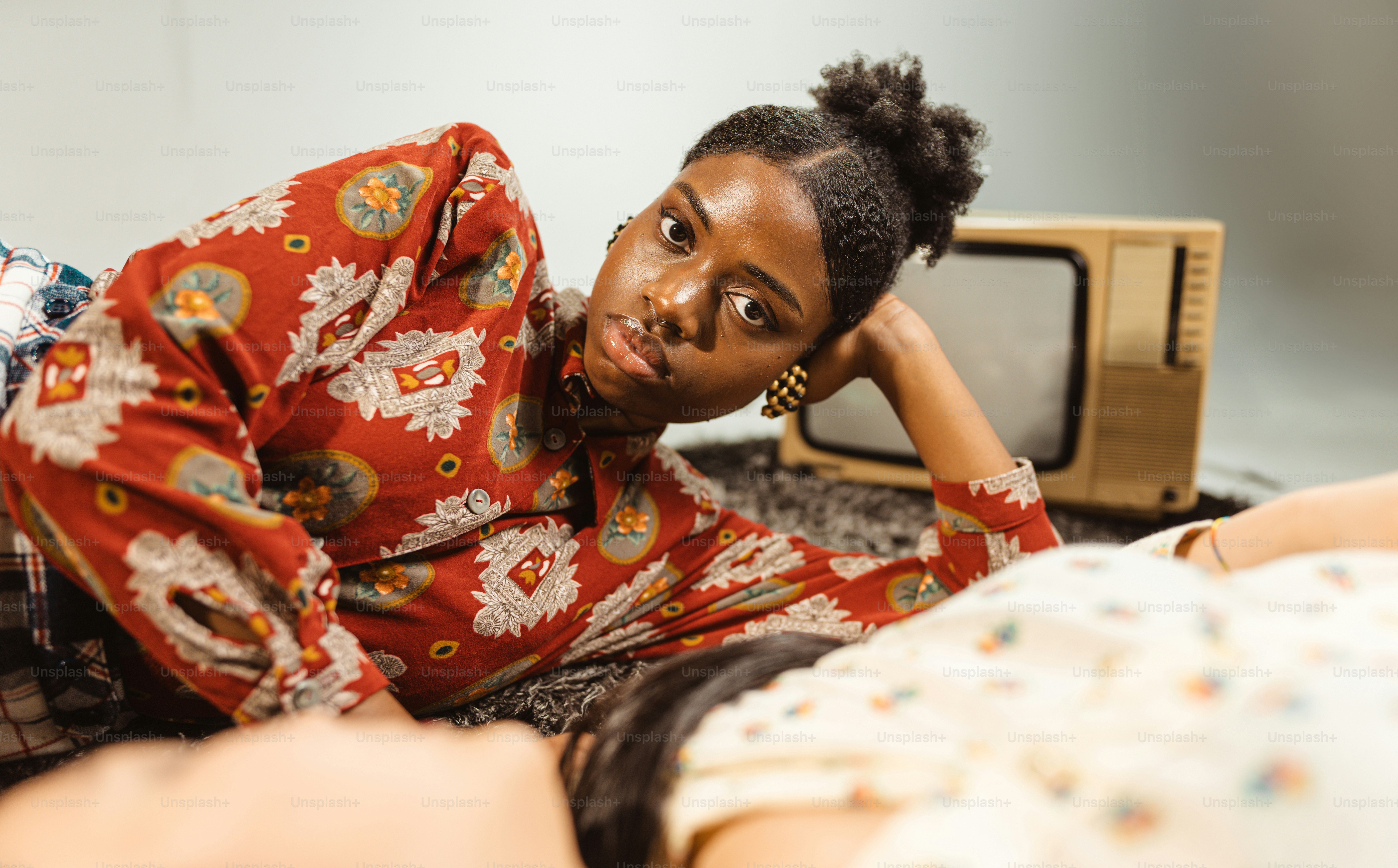 eine Frau, die auf einem Bett neben einem Fernseher liegt