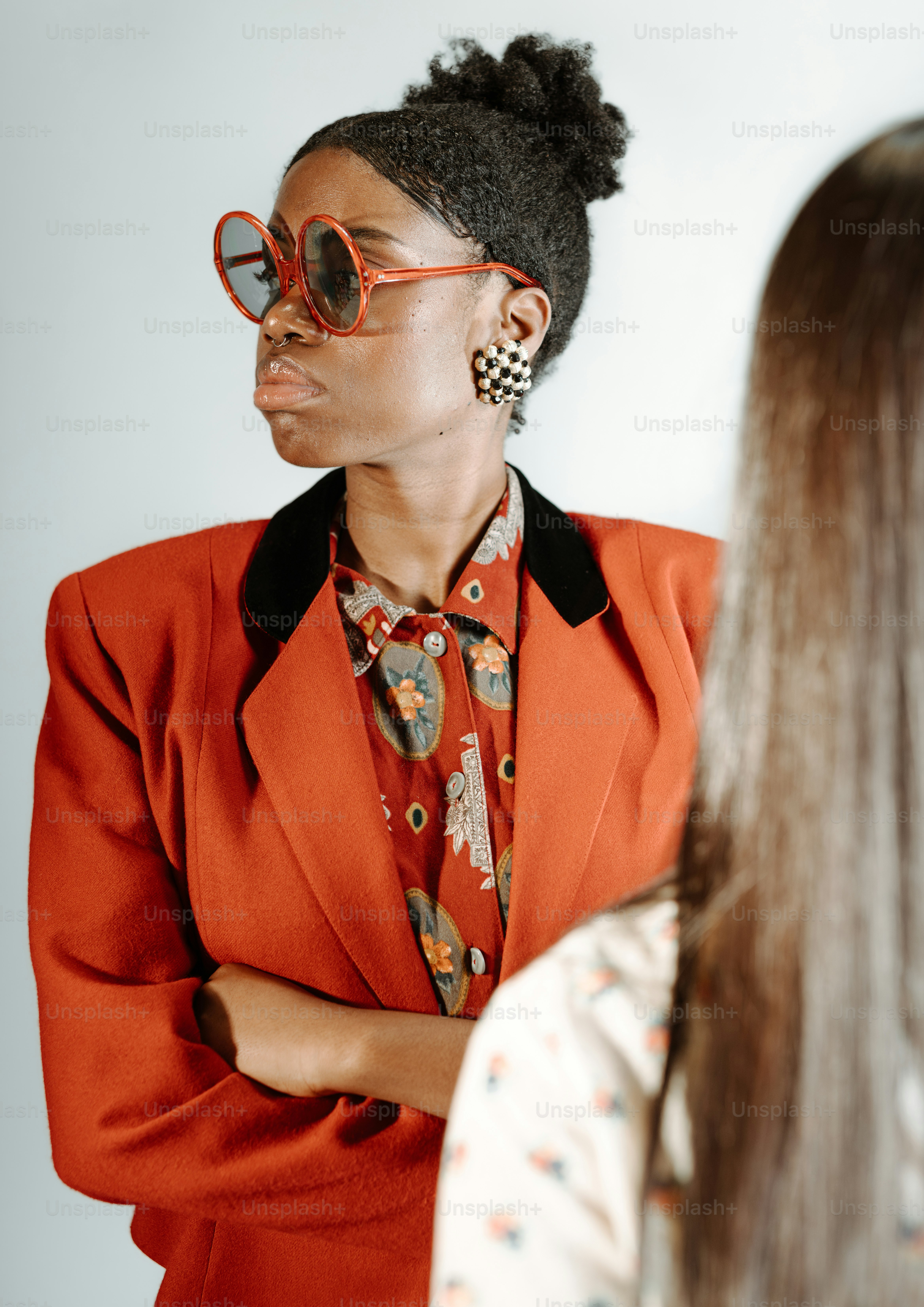 eine Frau in orangefarbenem Anzug und Sonnenbrille