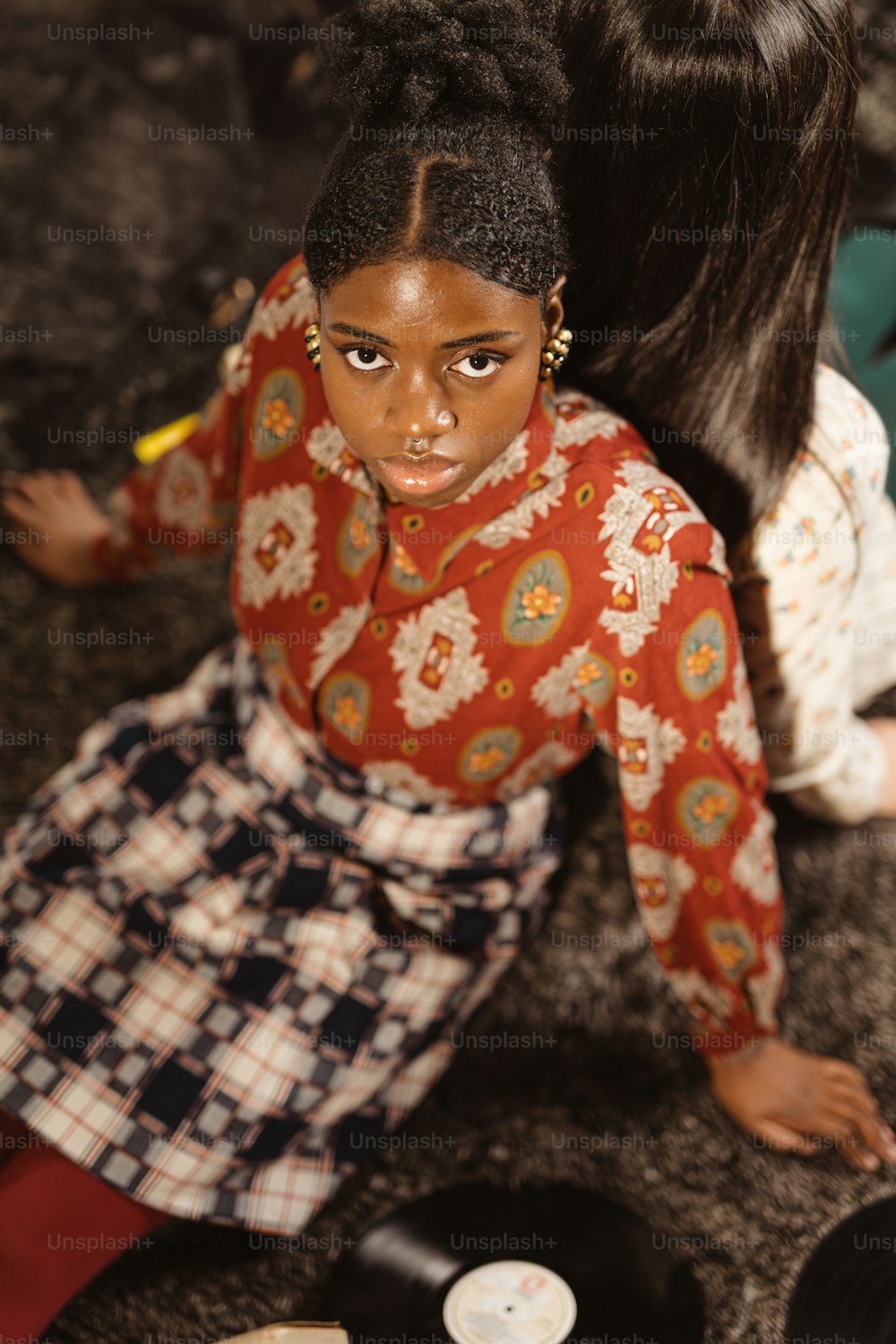 una joven sentada en el suelo junto a un tocadiscos