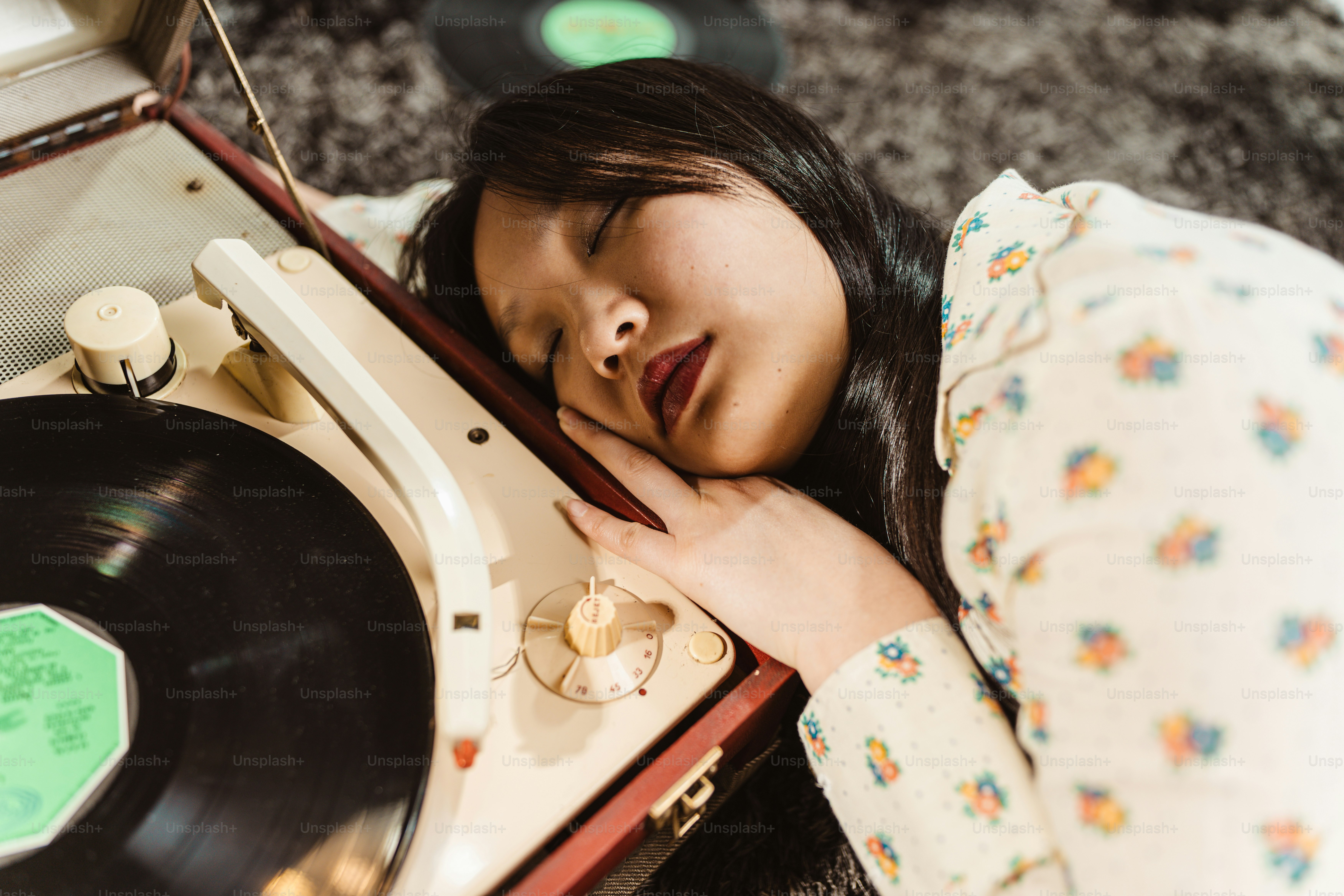 eine Frau, die ihren Kopf auf einen Plattenspieler legt