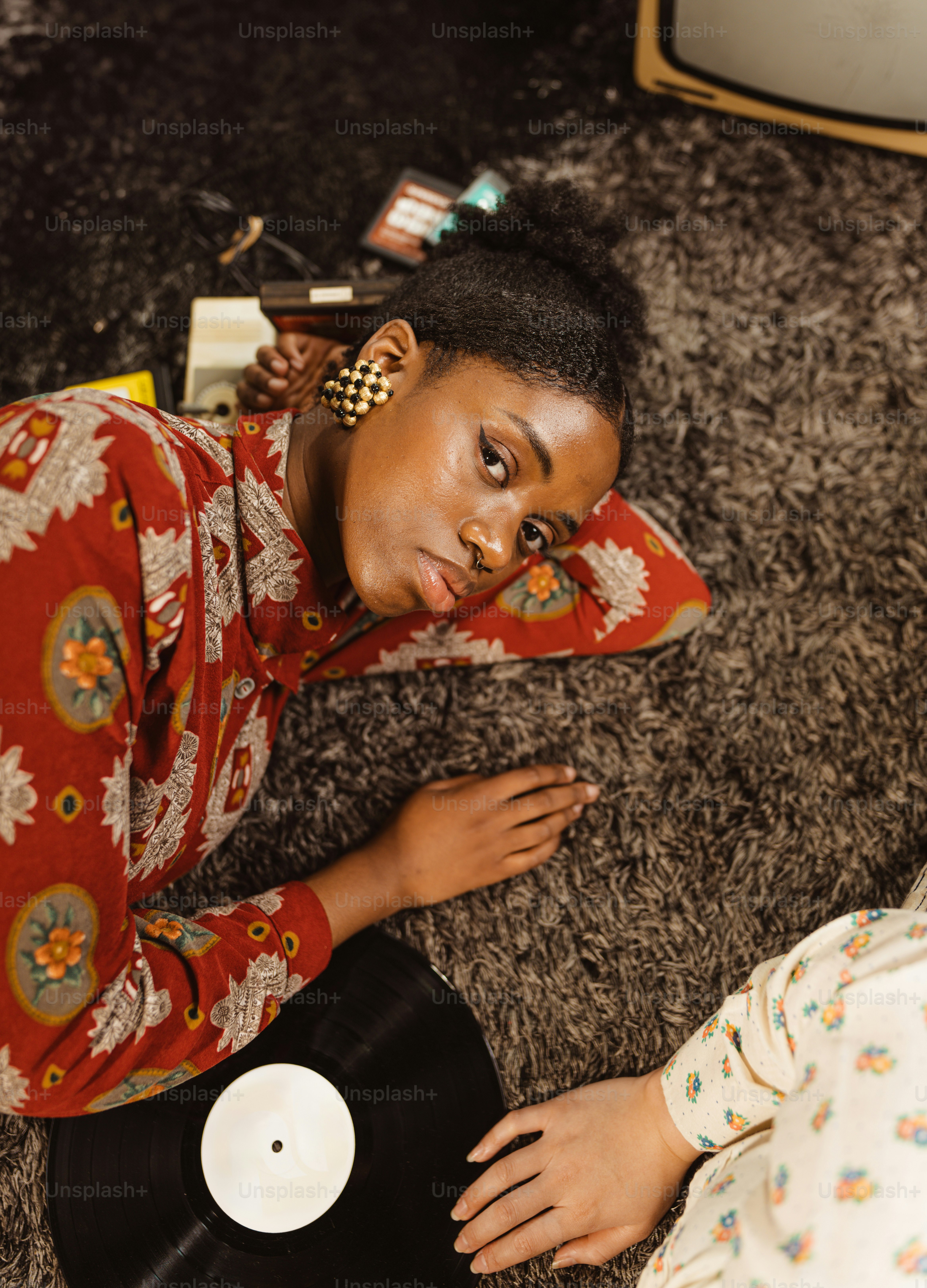 a woman laying on the floor next to a record player