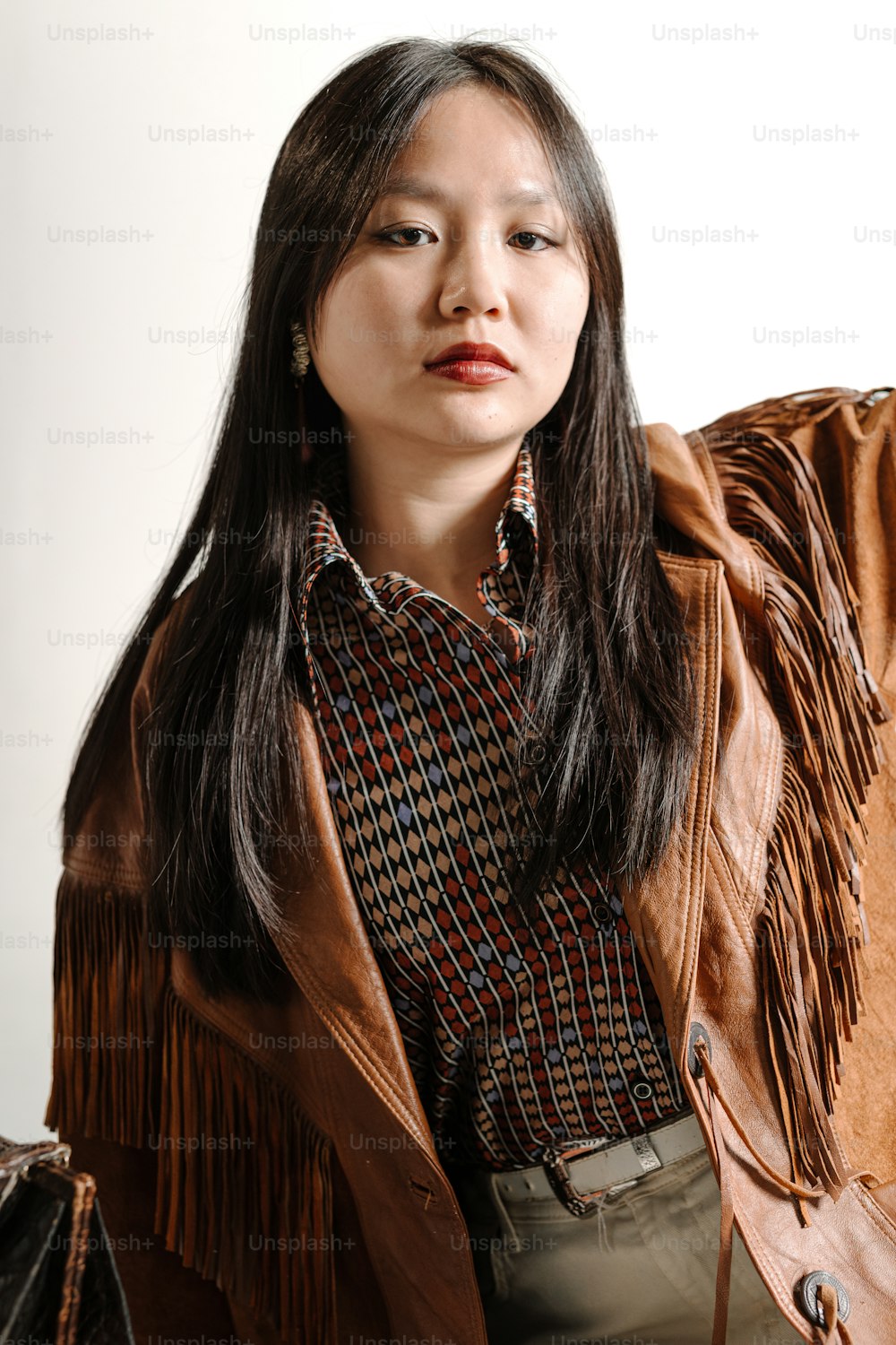 a woman with long hair wearing a brown jacket
