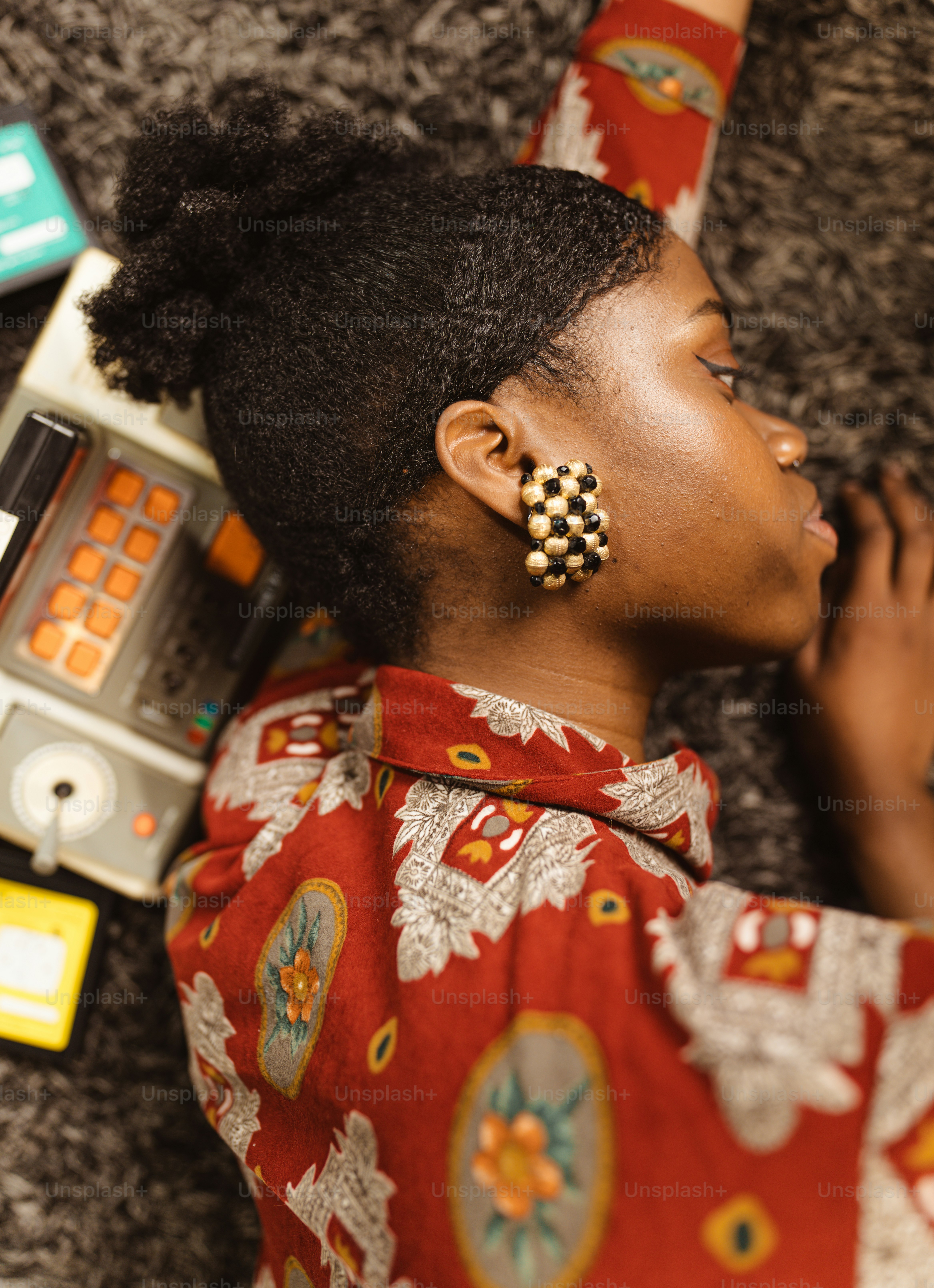 a woman laying on the floor next to a radio