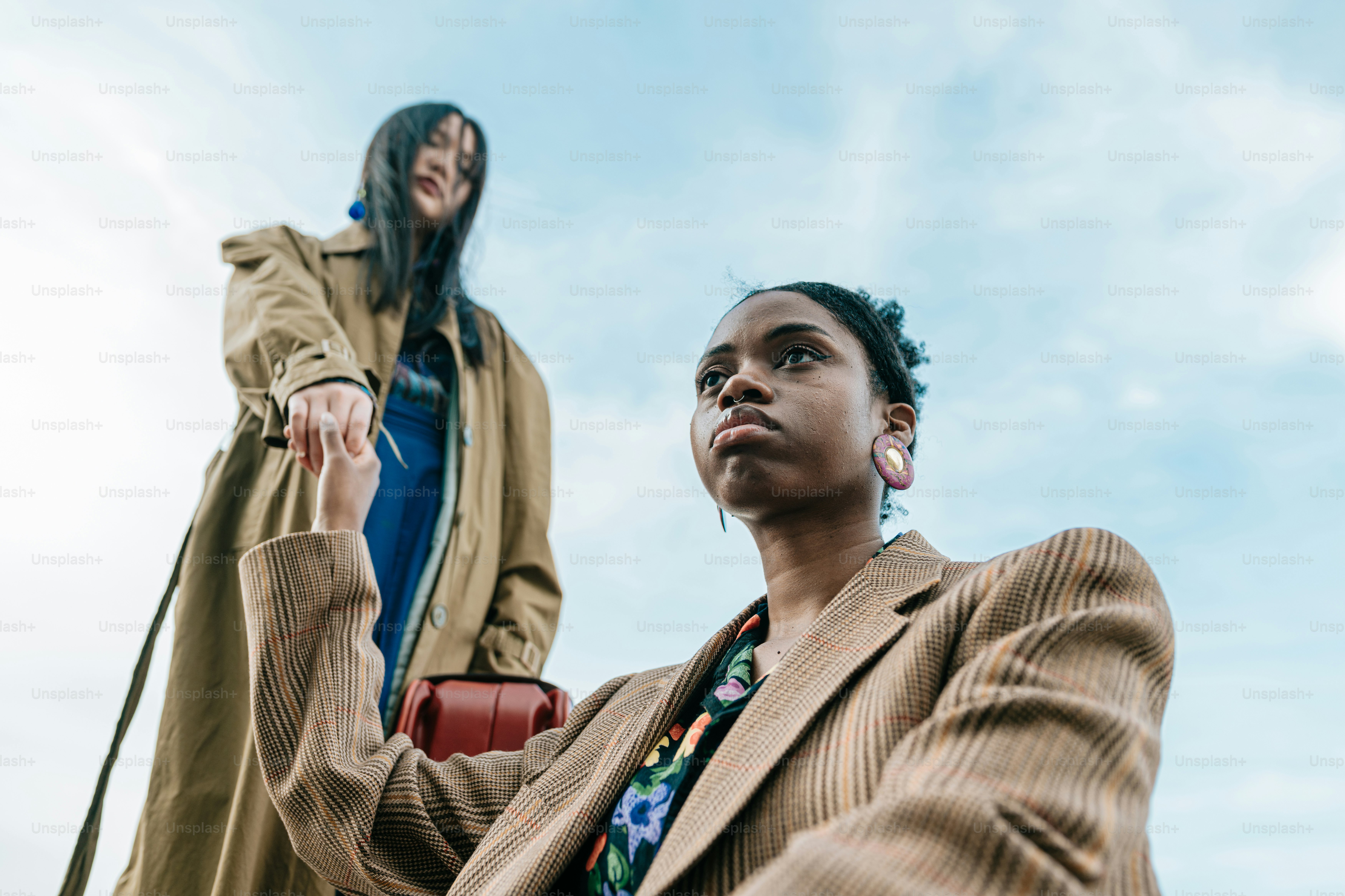 a woman standing next to a woman holding a purse