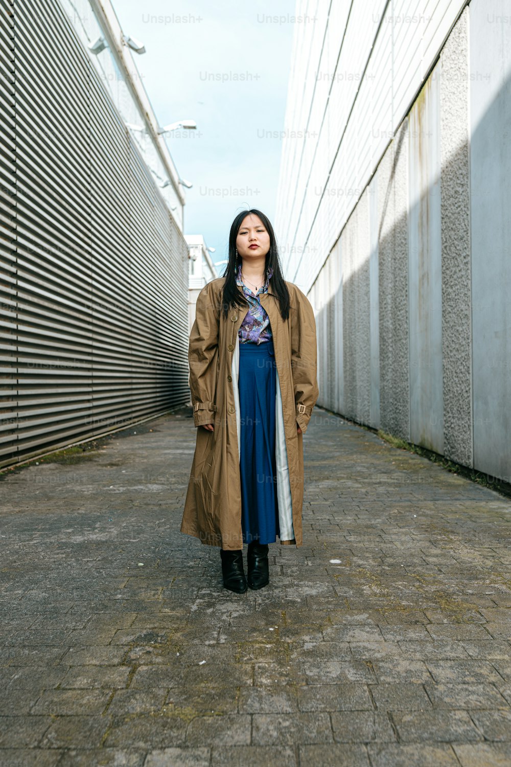 a woman standing in an alley with her eyes closed