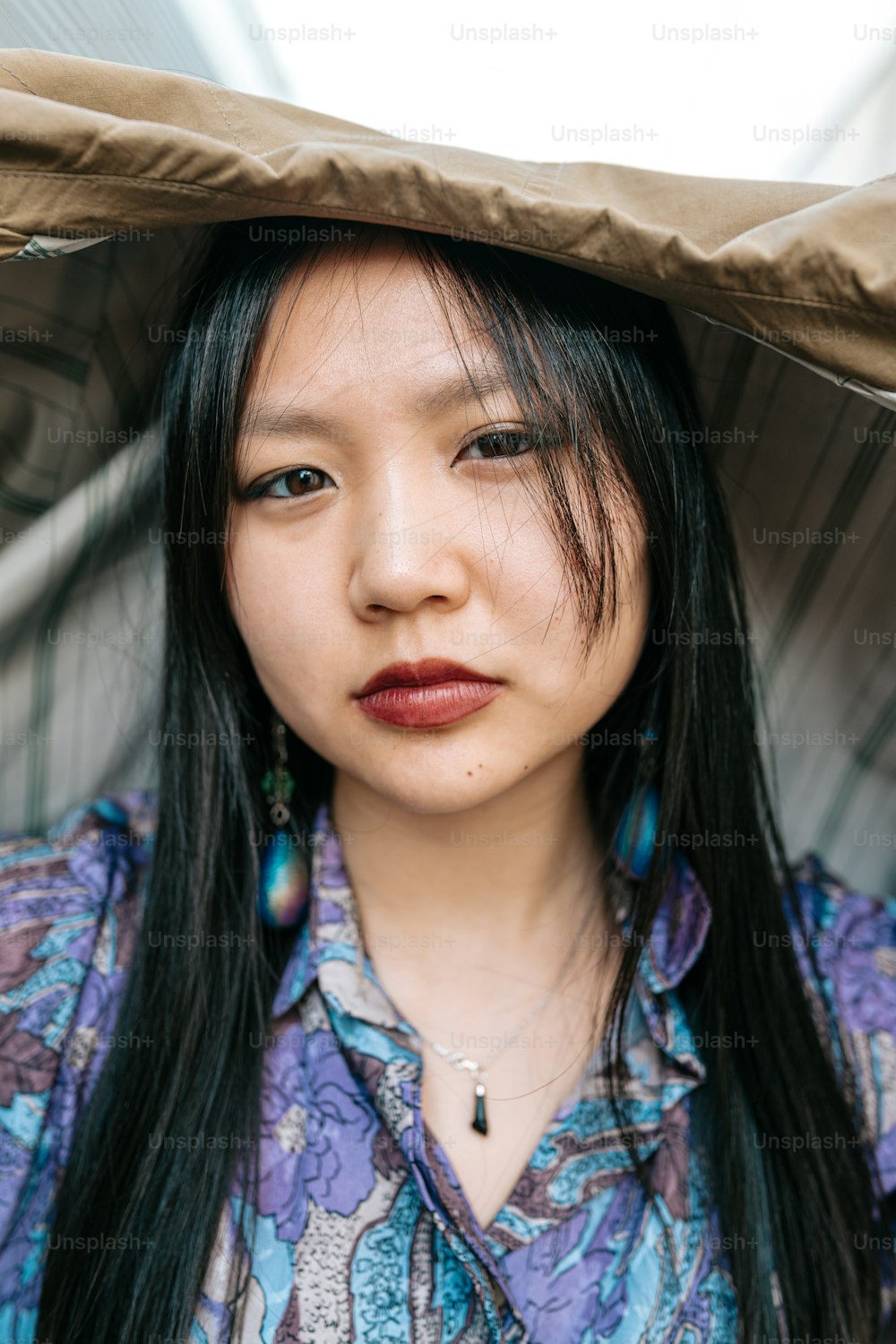 a woman with long black hair wearing a hat