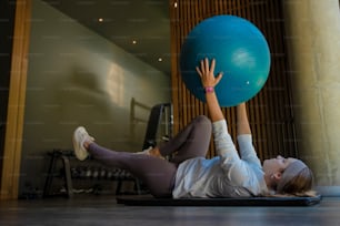 a woman laying on the floor with a large blue ball