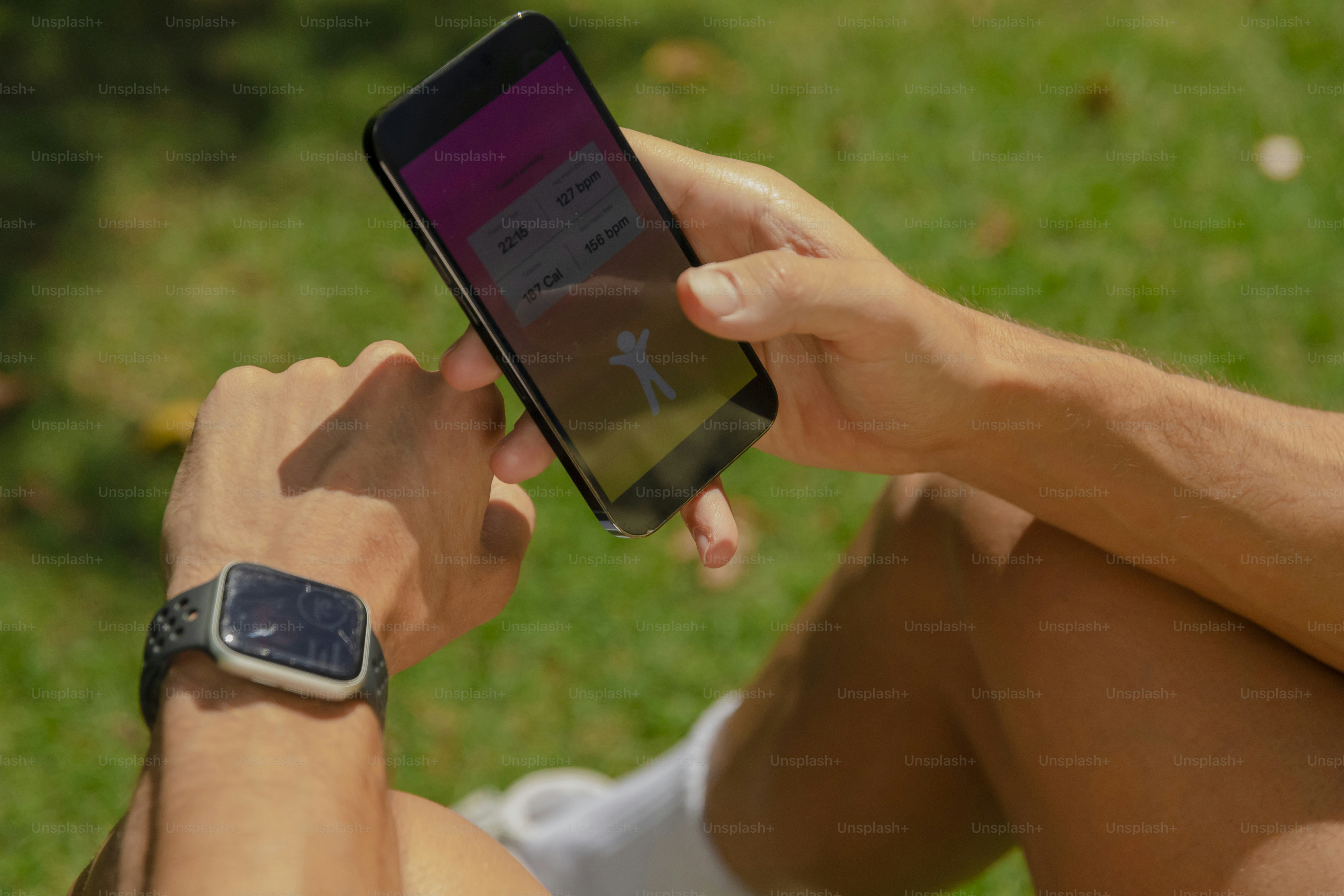 a person sitting on the grass using a cell phone