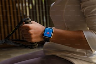 a woman is holding a smart watch with a blue screen