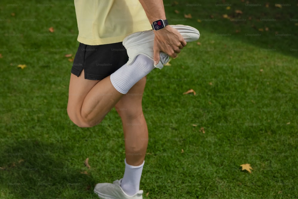 Una mujer con una camisa amarilla y pantalones cortos negros sosteniendo un frisbee blanco