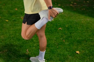 a woman in a yellow shirt and black shorts holding a white frisbee