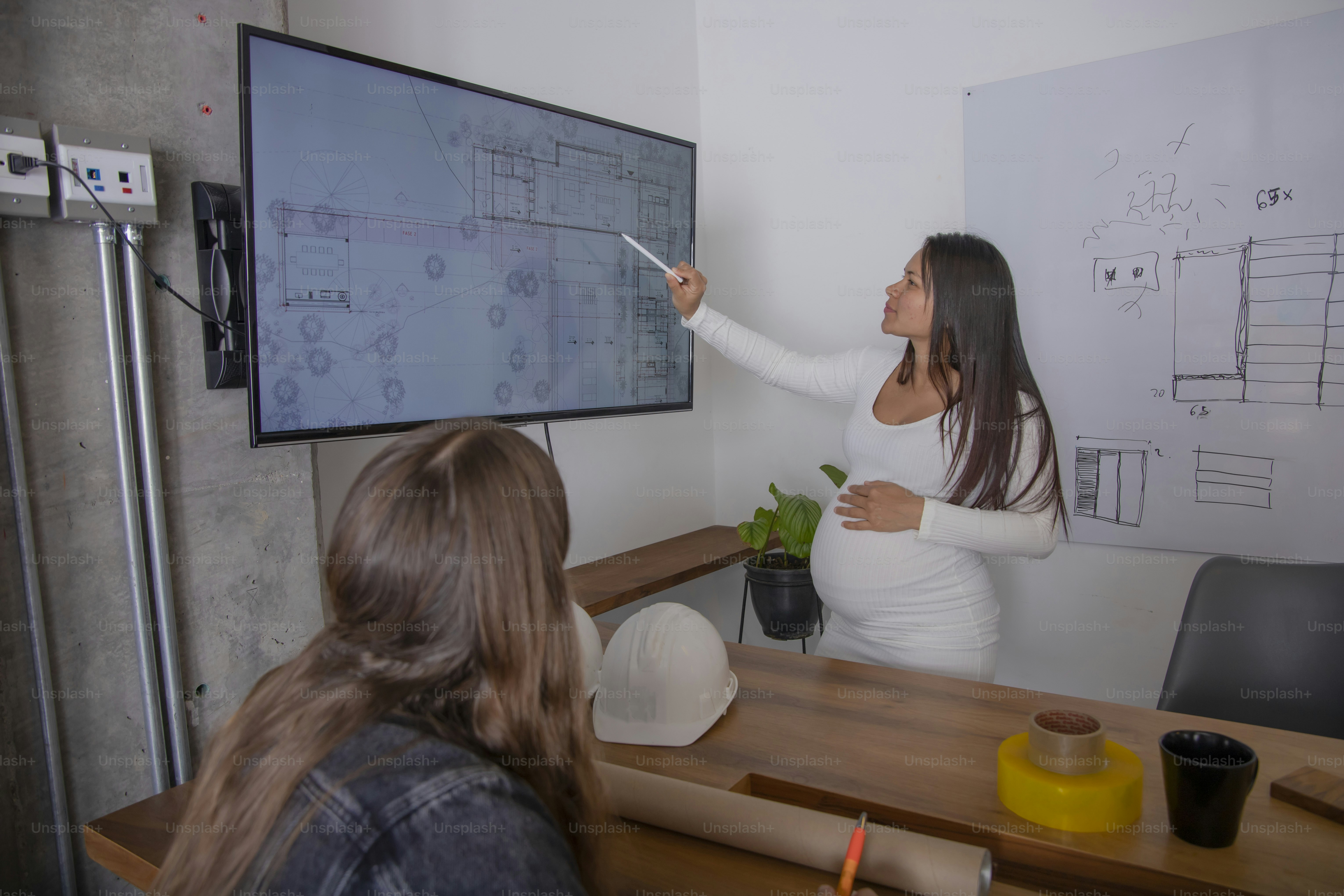 a woman is pointing to a projector screen