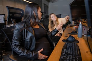 a pregnant woman sitting in front of a computer