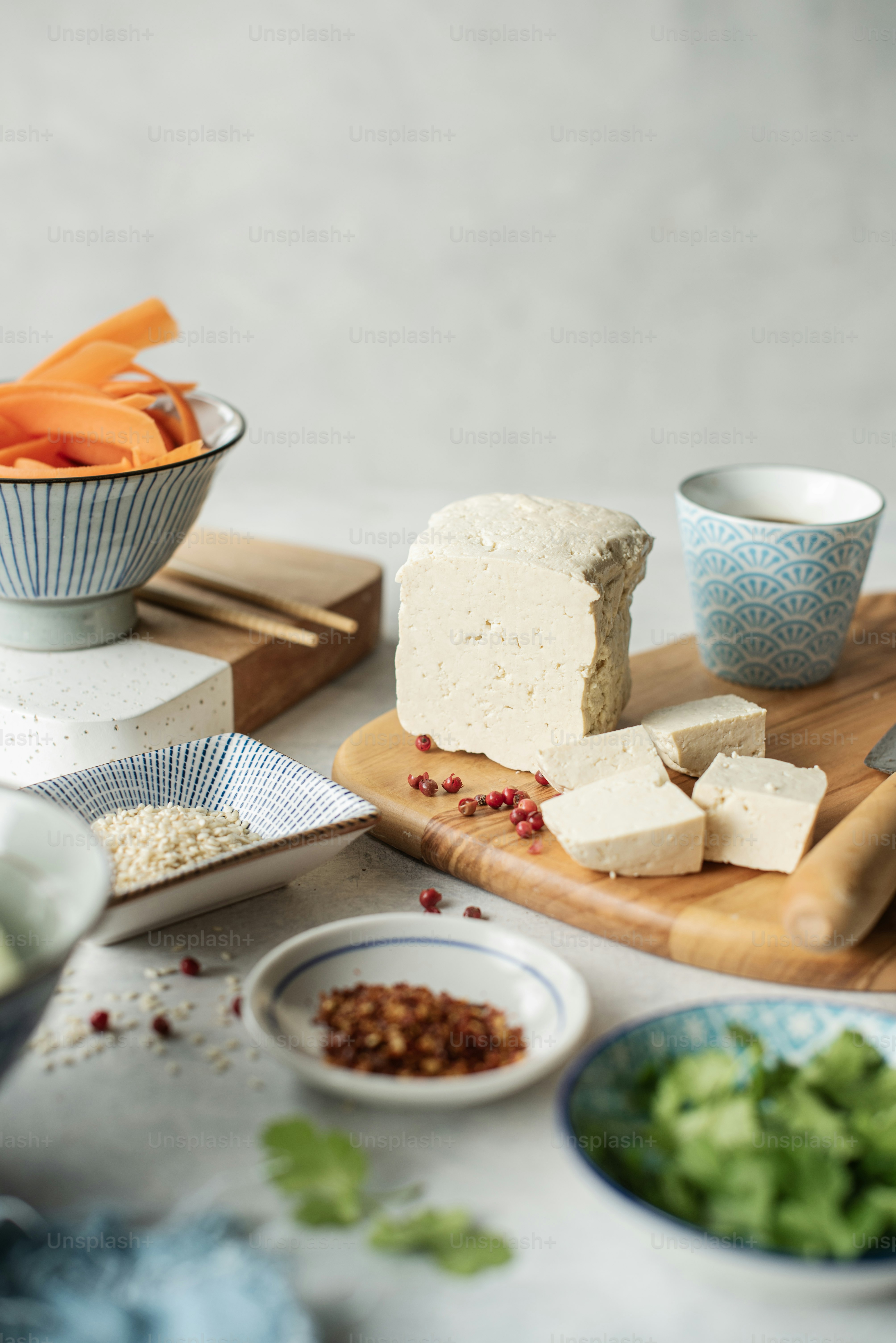 a table topped with bowls of food and a cutting board