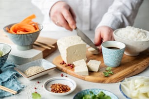 une personne qui découpe de la nourriture sur une planche à découper