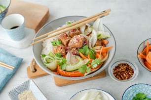 Uma tigela de comida asiática com pauzinhos ao lado