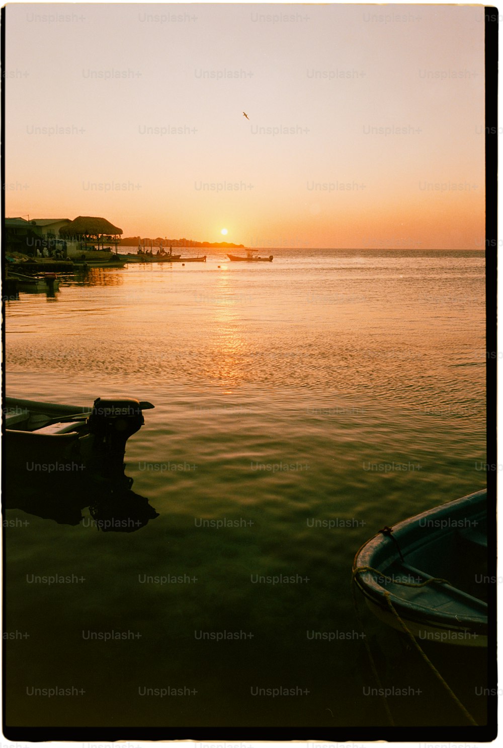 Un bateau est assis dans l’eau au coucher du soleil