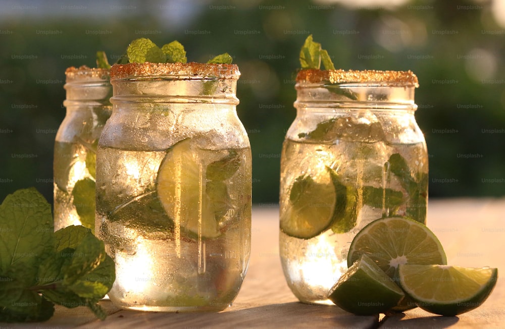 two mason jars filled with lemonade and limes