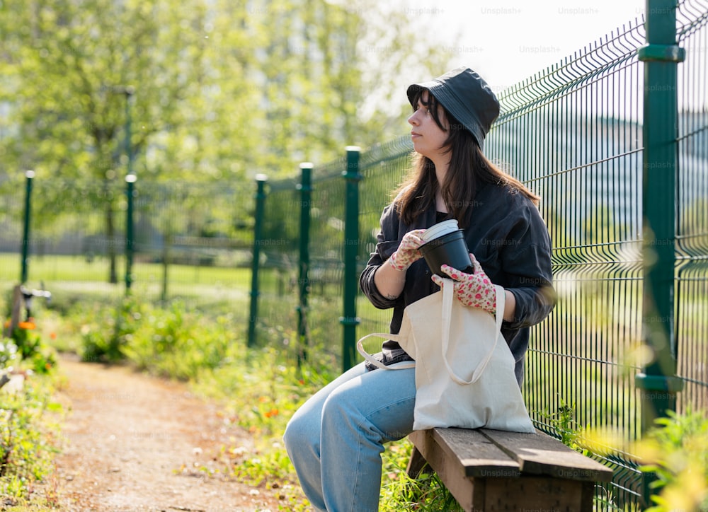 a woman sitting on a bench holding a coffee cup