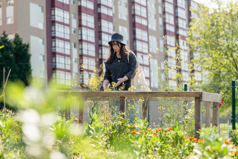 a woman standing on a wooden bench in a garden