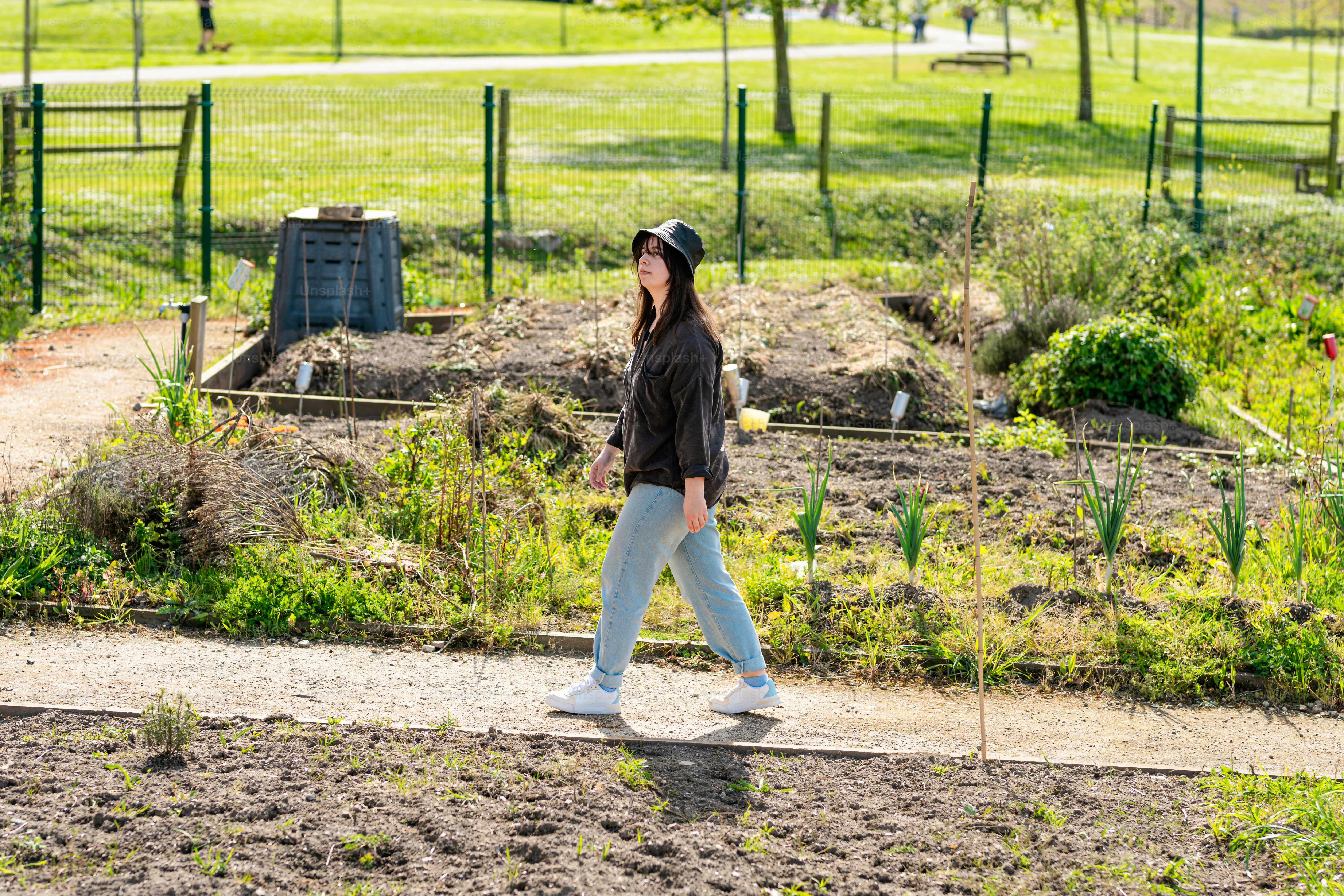 a woman walking down a path in a park