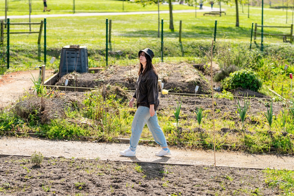eine Frau, die einen Weg in einem Park entlanggeht