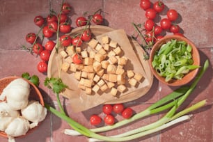 a wooden cutting board topped with tofu and vegetables